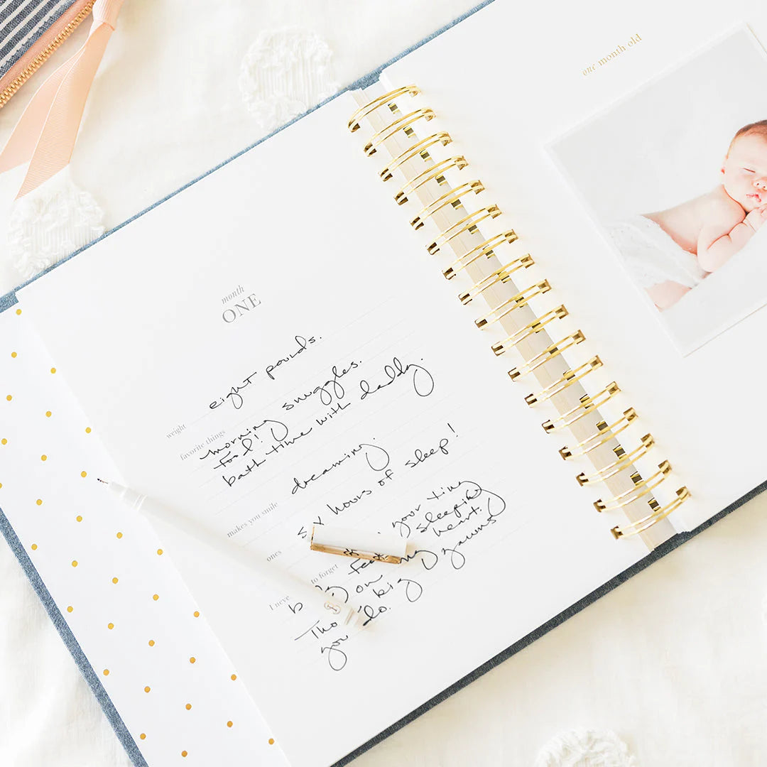 Sugar Paper baby book in chambray, open at the first month page