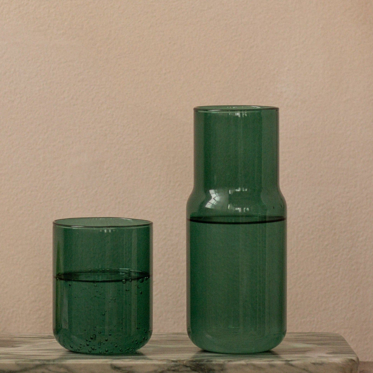 Gry Mattr tinted glass carafe and cup in forest green, filled with water