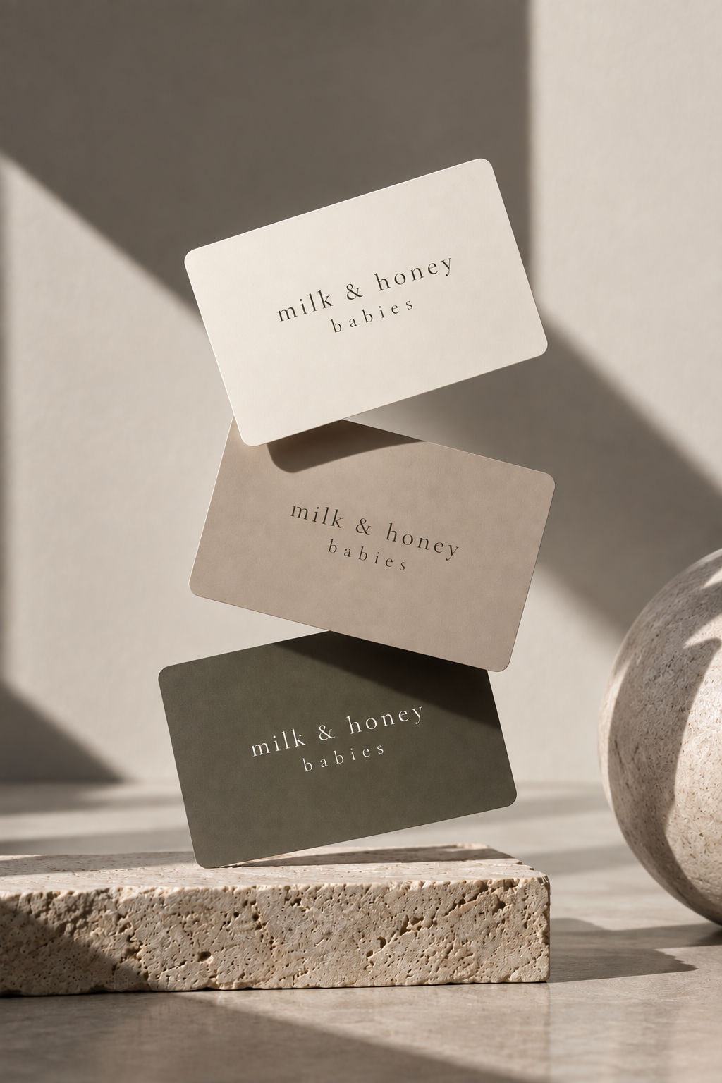 milk & honey babies gift cards in cream, stone and olive, on travertine
