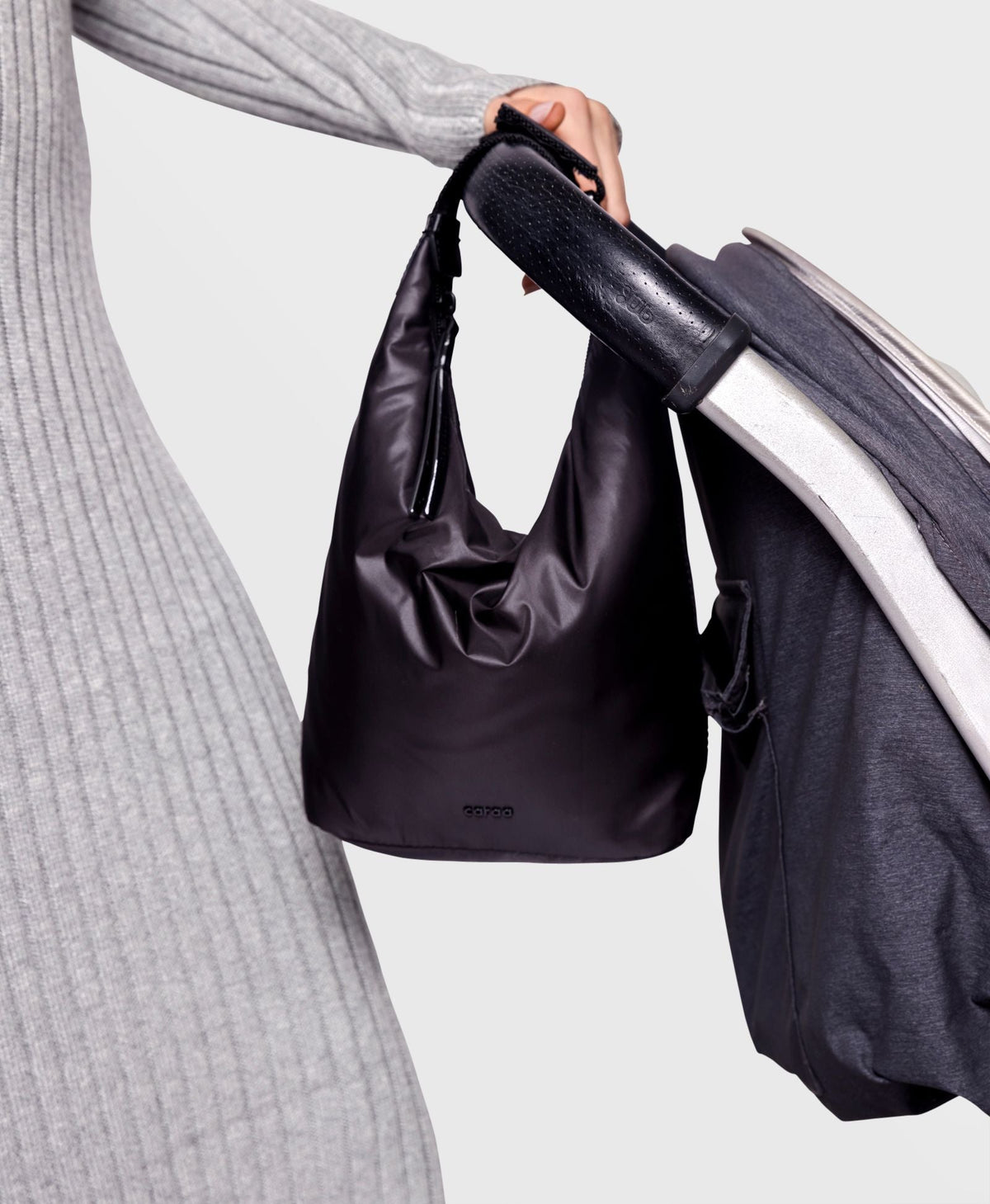 Caraa Baby Bottle Bag in Black hooked onto a stroller handle