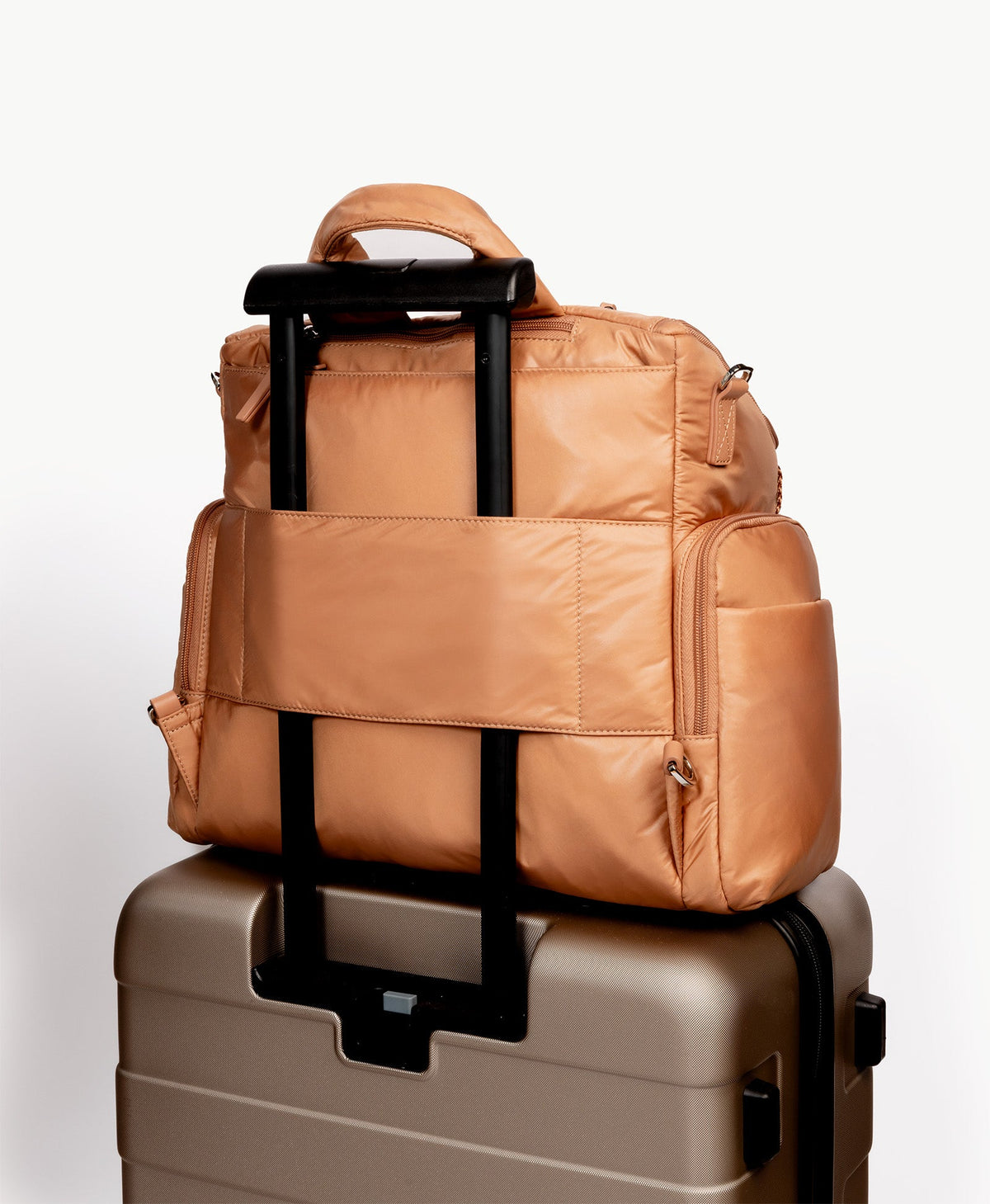Caraa Baby Bag Large in Mocha Mousse on a suitcase handle