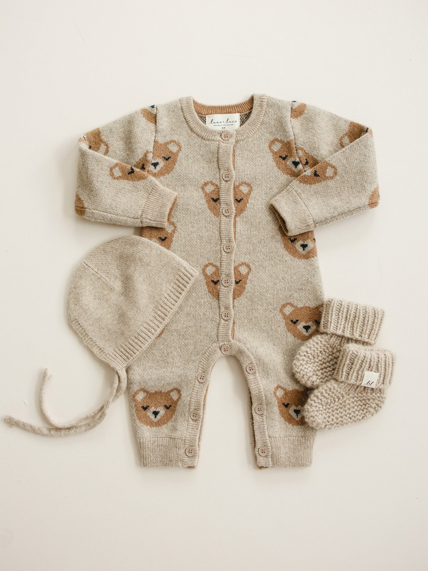 Newborn in the brown cashmere jumpsuit and tie bonnet