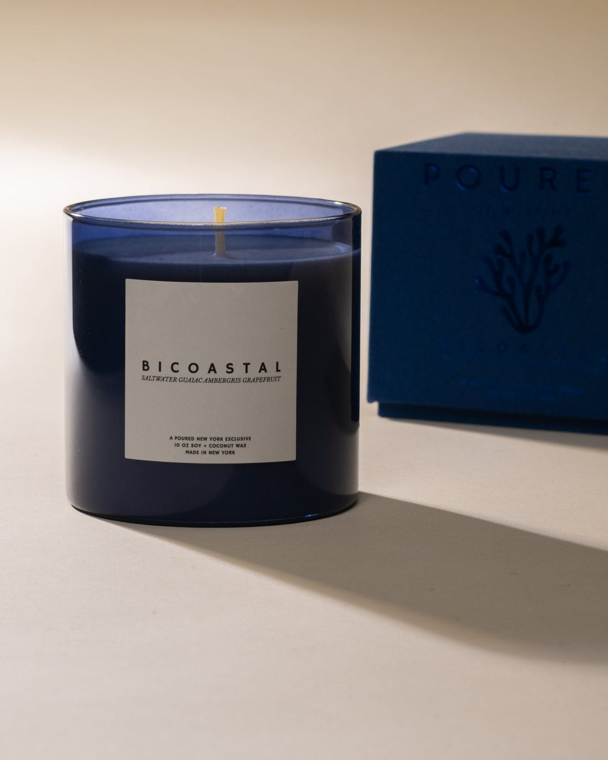 Poured New York Bicoastal candle in blue glass with its box