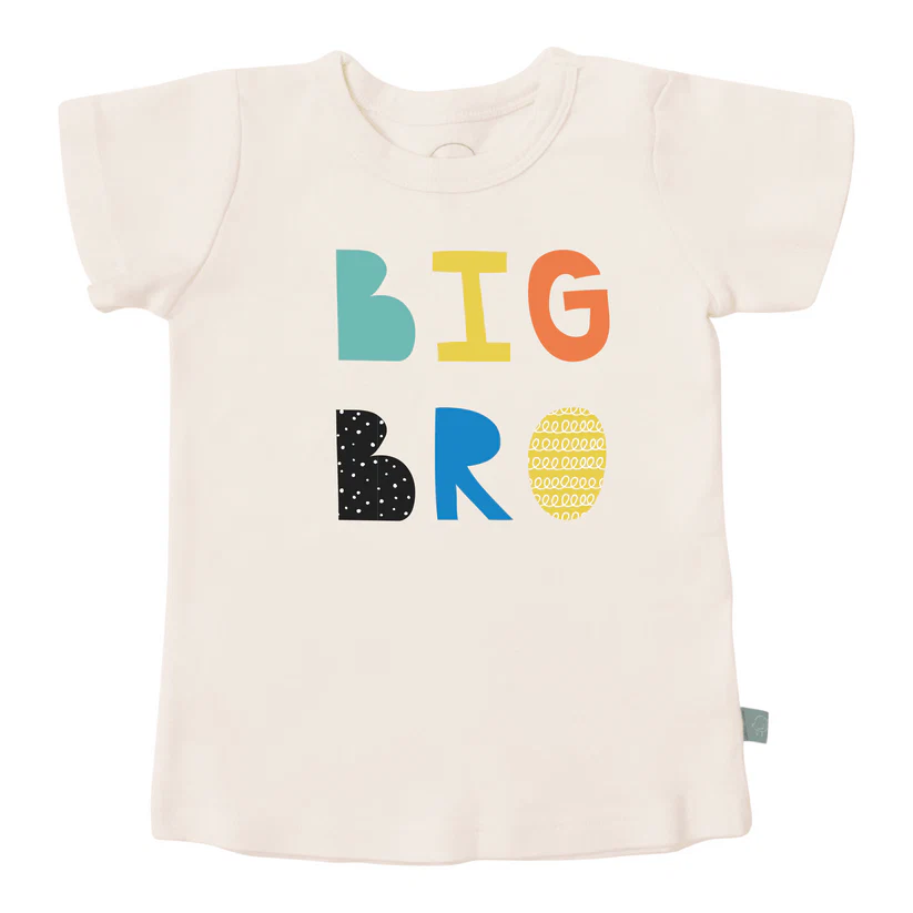 The Big Brother Edit laid out with tee, bodysuit, book and plush