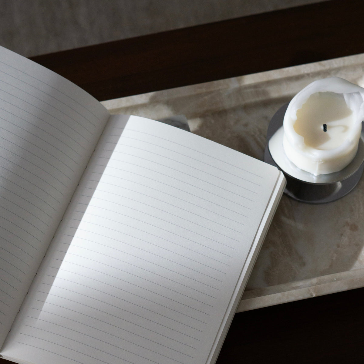 Notes to Self lined journal open, blank lined pages beside a candle