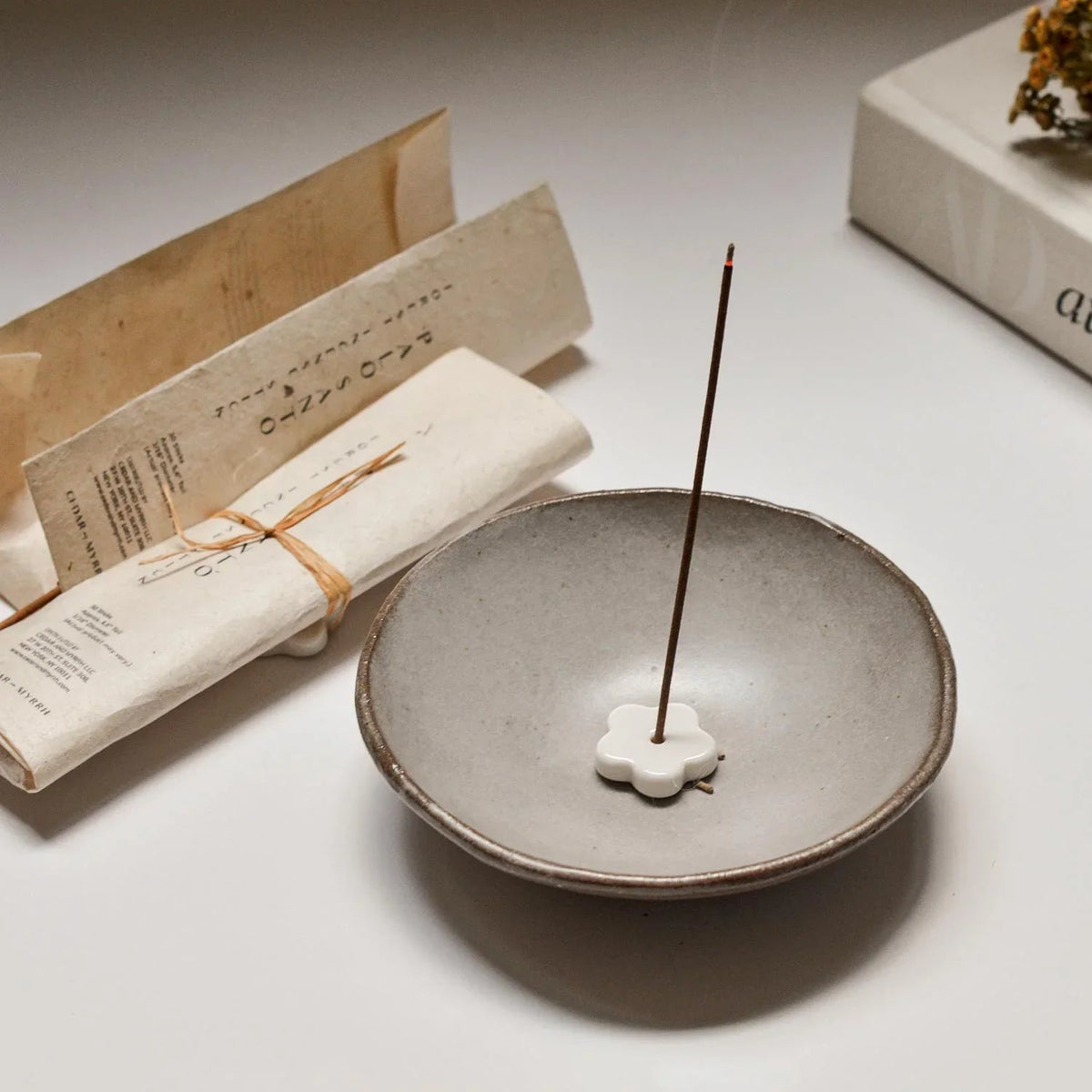 Palo santo incense burning beside its washi-style paper wrap