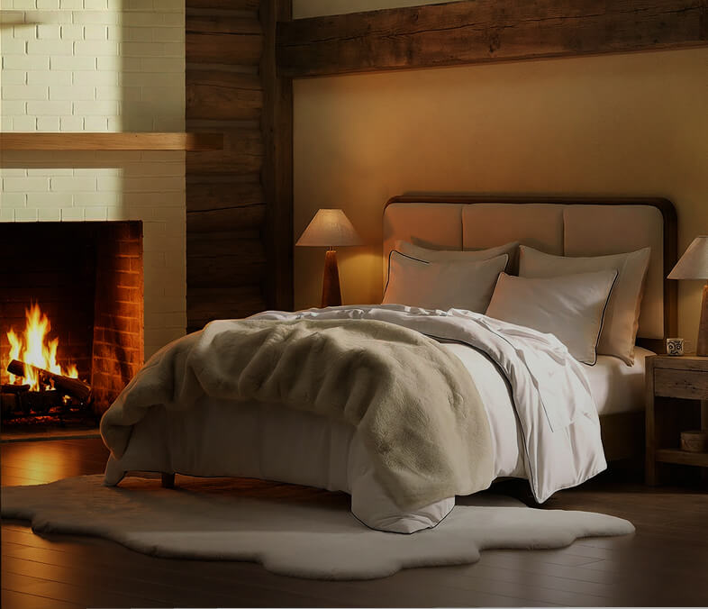 Sunday Citizen faux fur bed runner in taupe, in a room with a fireplace