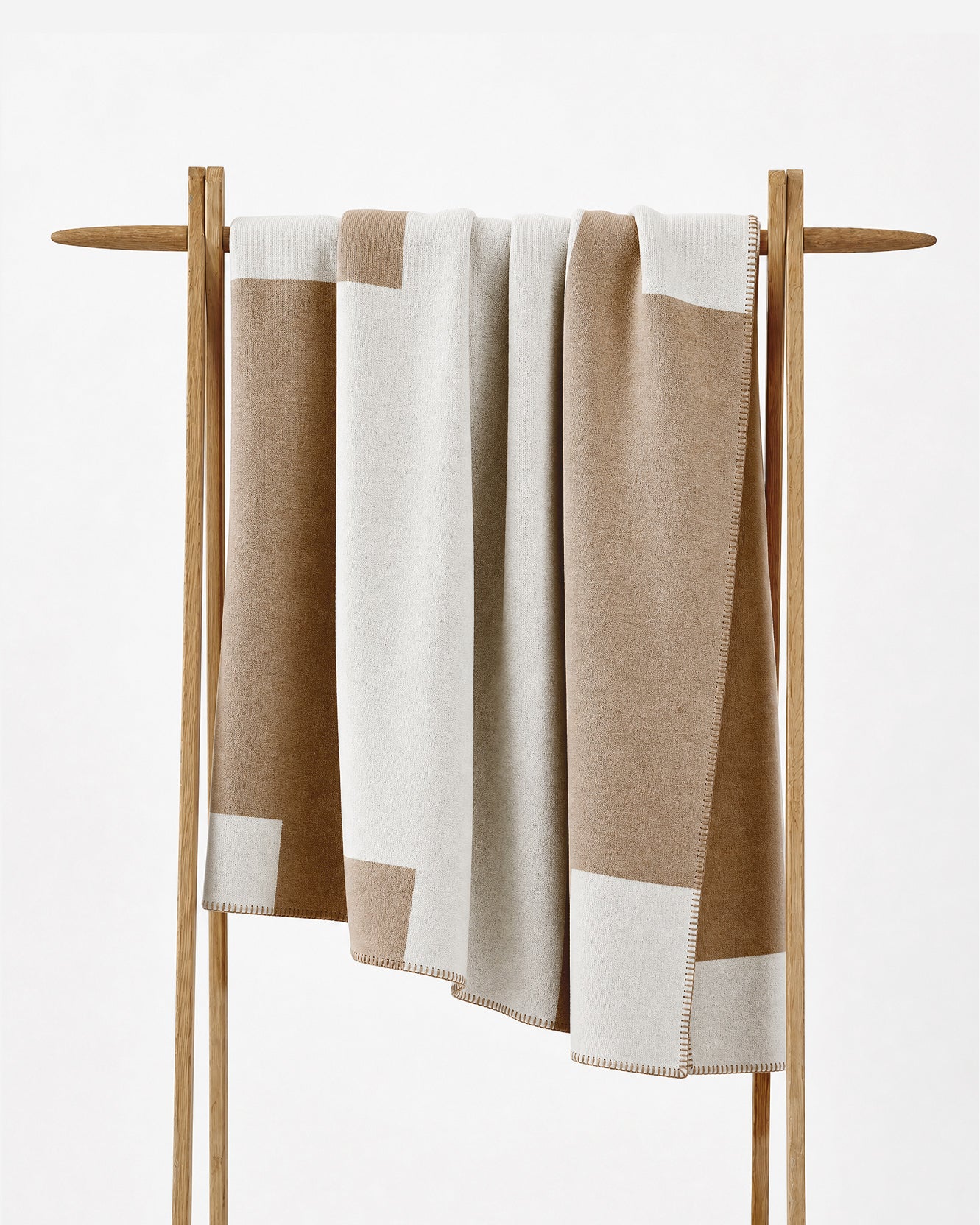 The throw on a stand, showing the blocked tan and off white