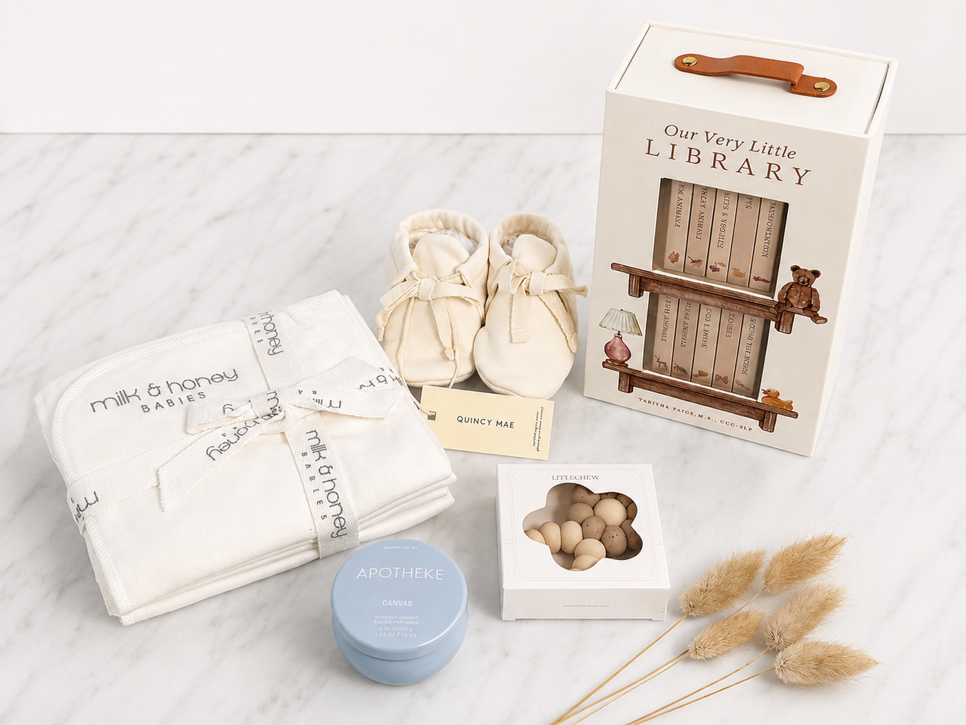 The Welcome Edit with organic burp cloths, undyed booties, littleCHEW teether, Apotheke Canvas candle, and Our Very Little Library board book set